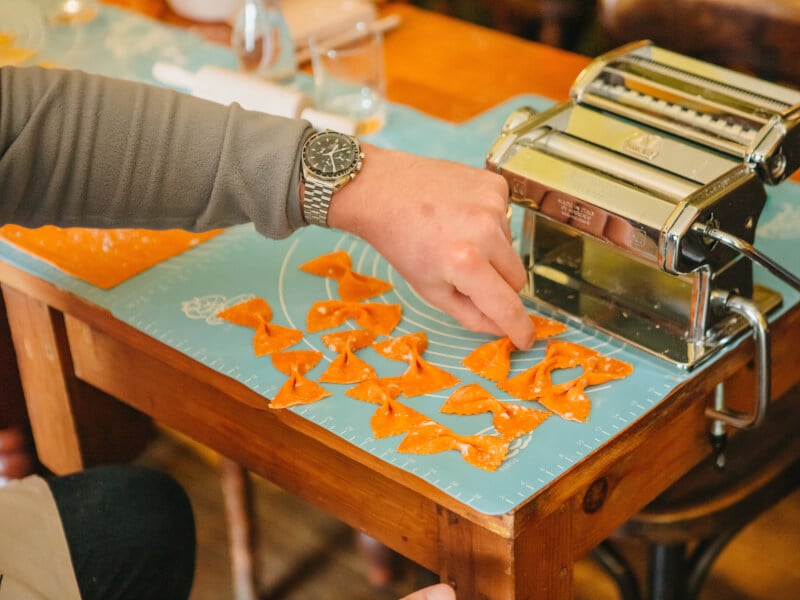 Handmade pasta next to a pasta machine