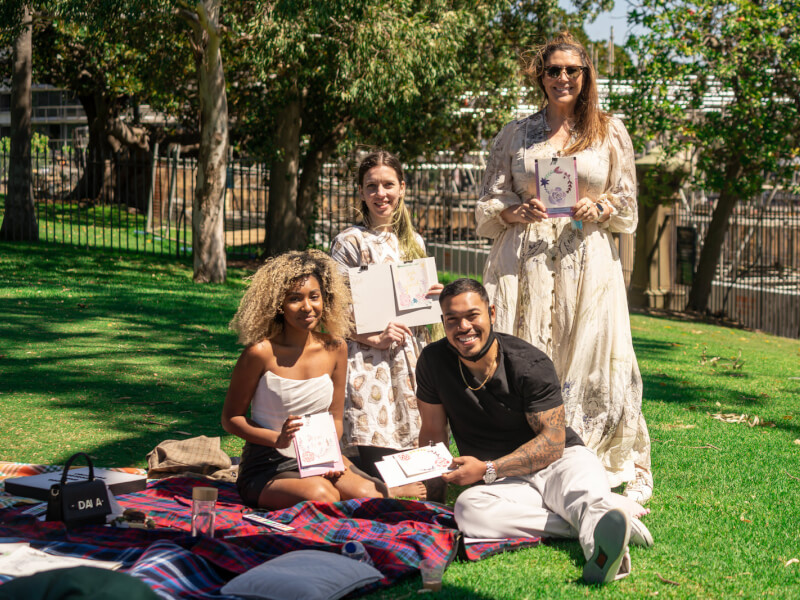 People showing off their watercolour artworks outside