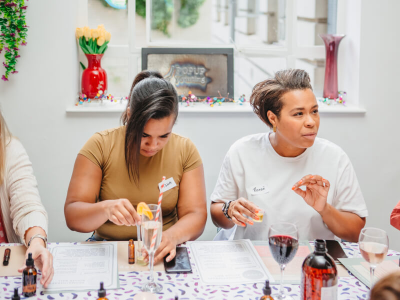 Two people surrounded by essential oils making perfume for Valentine's Day