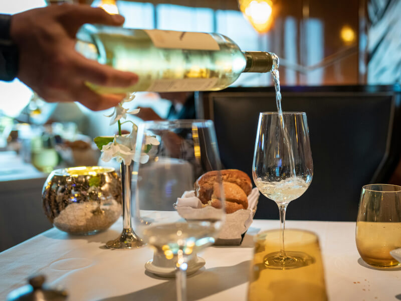 Person pouring wine in a glass