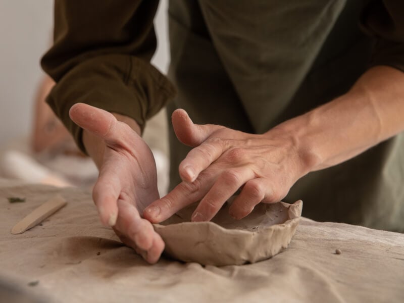 person shaping clay