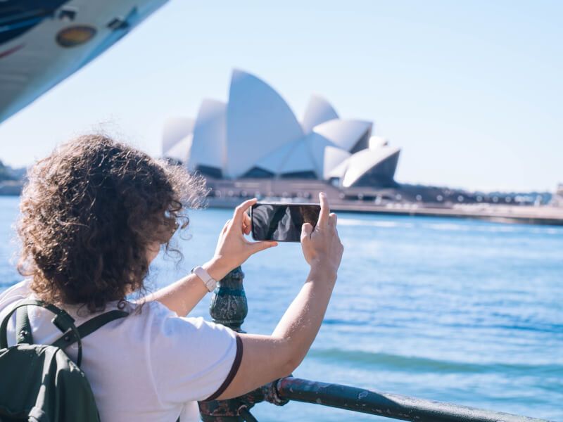 A woman taking photos of Sydney Opera House at a photography workshop