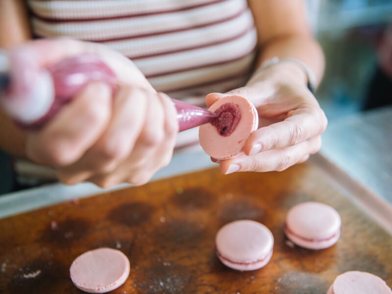 Person piping macarons at a Brisbane cooking class
