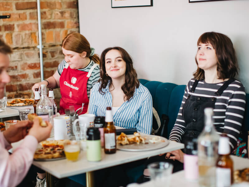 Employees eat their handmade pizza at team cooking lunch