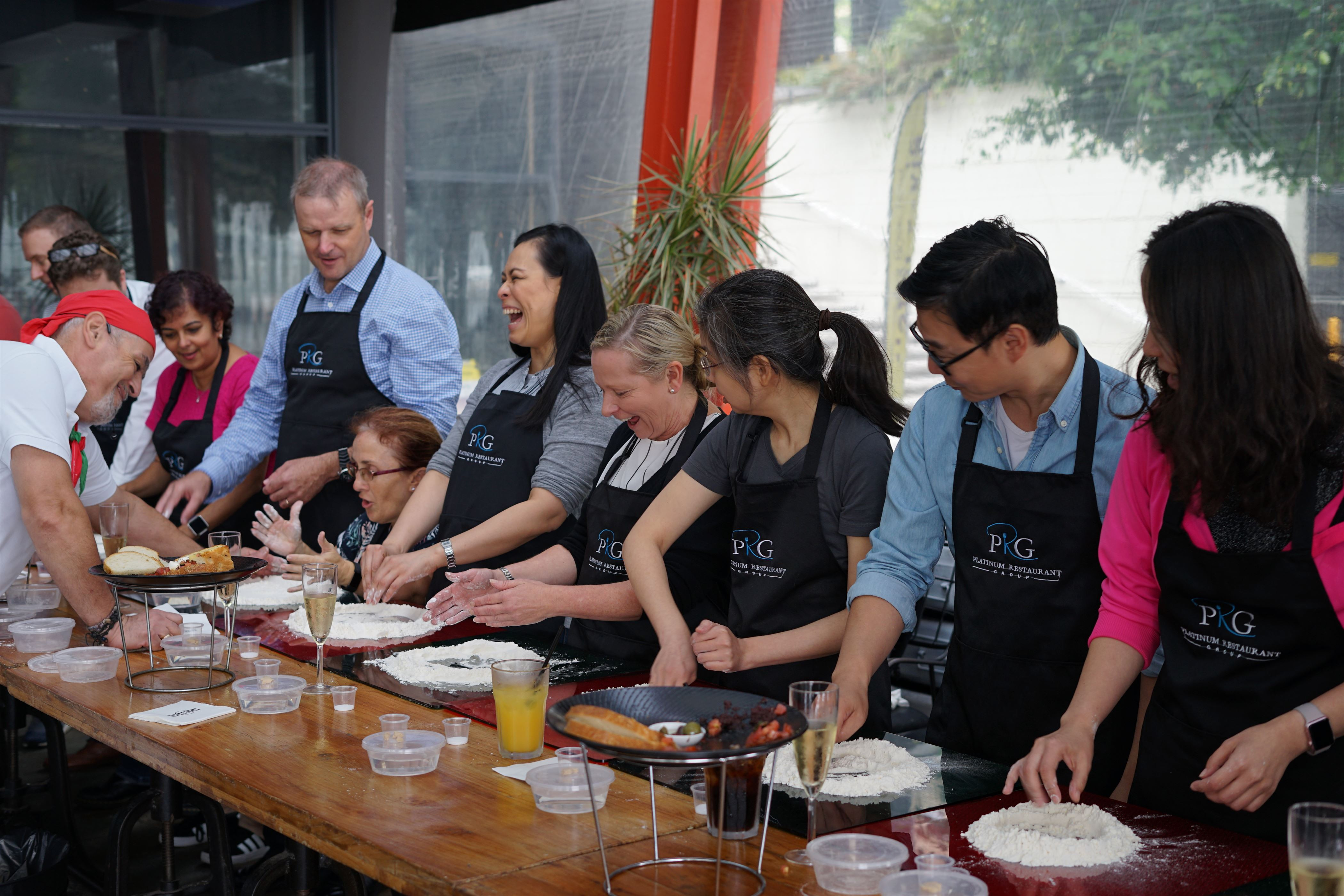 People laughing and making pizza