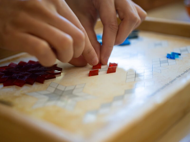 Person placing mosaic tiles