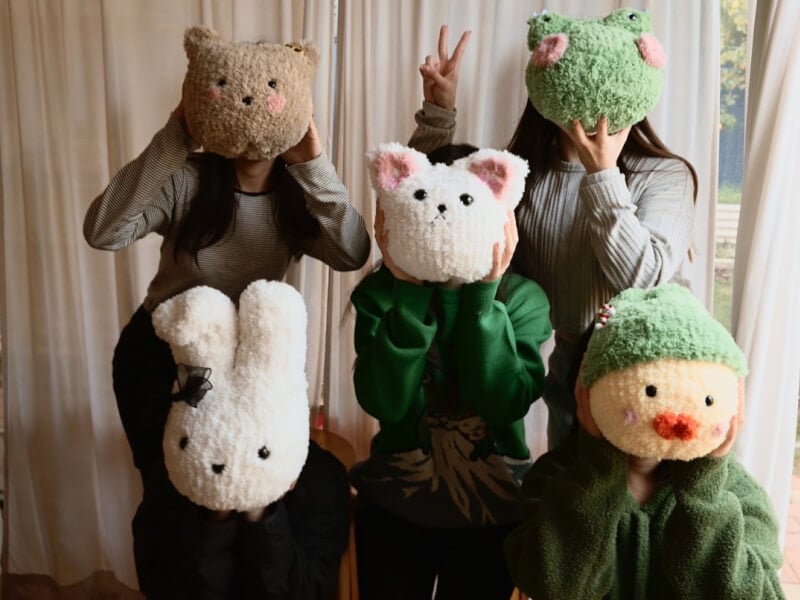 A group of friends pose with their handmade plushie gifts