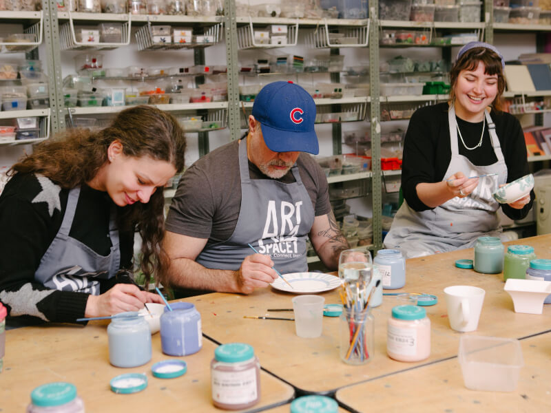 Colleagues painting pottery together