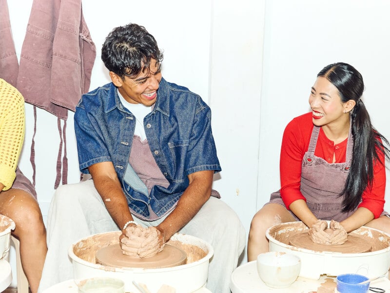 man and woman at pottery wheel throwing class