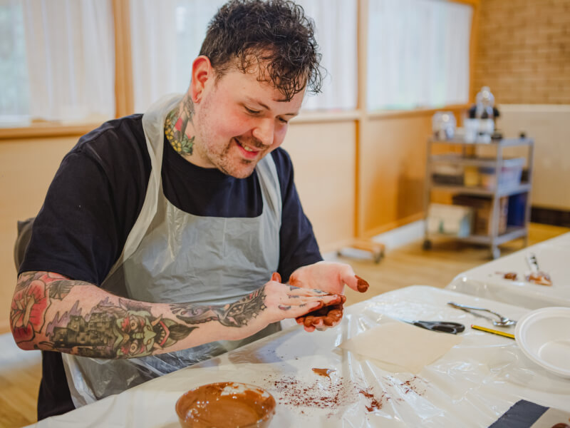 A man rolls chocolate into truffles at a cooking lesson