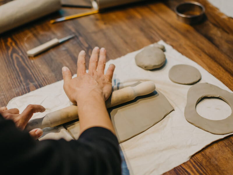 Person rolling out clay with rolling pin