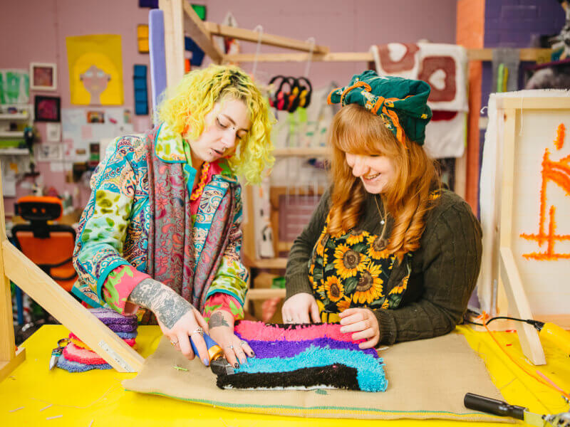 A couple tufting a rug together