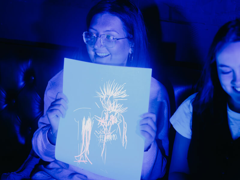 A woman displays her neon life drawing