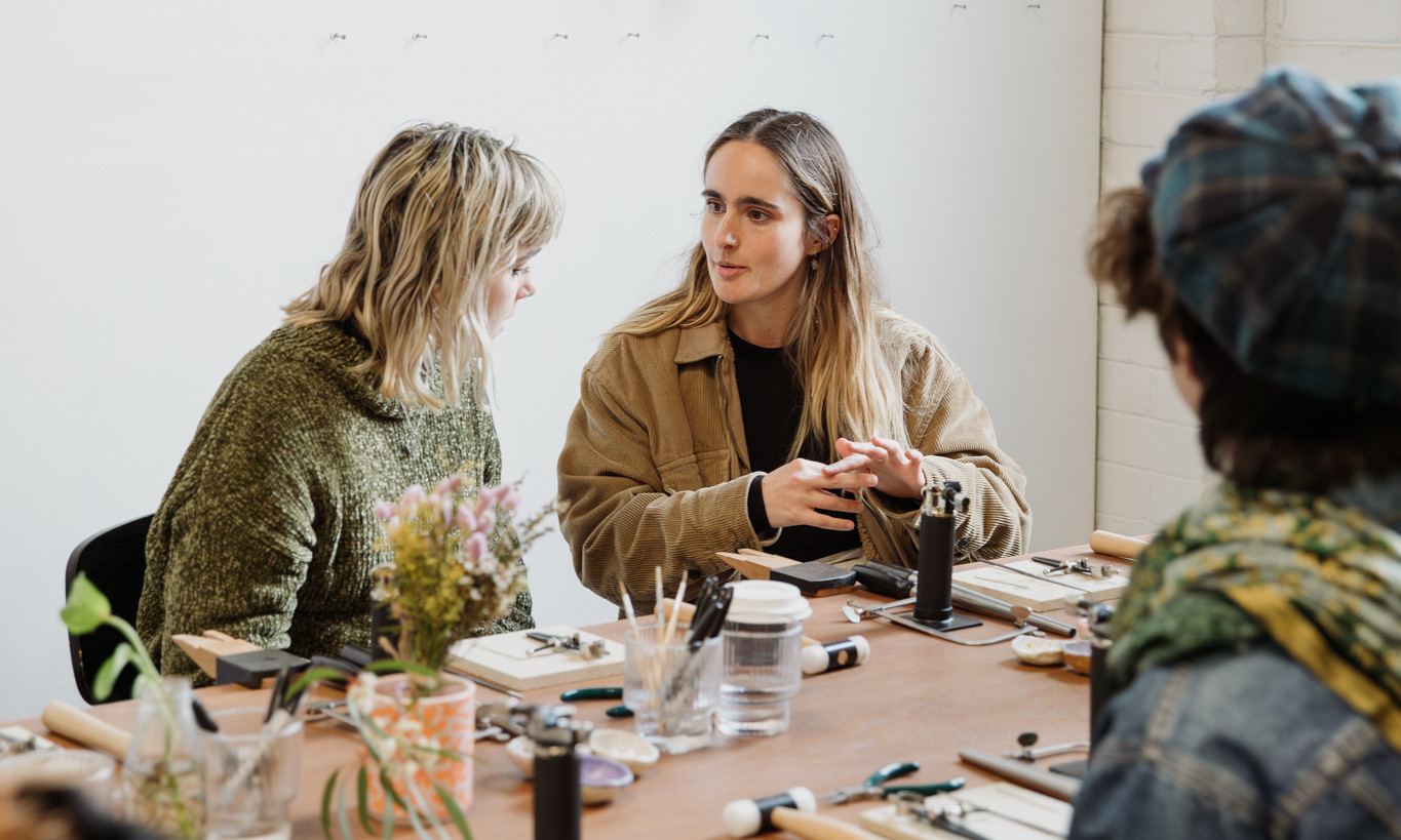 People talking to each other at a silversmithing class