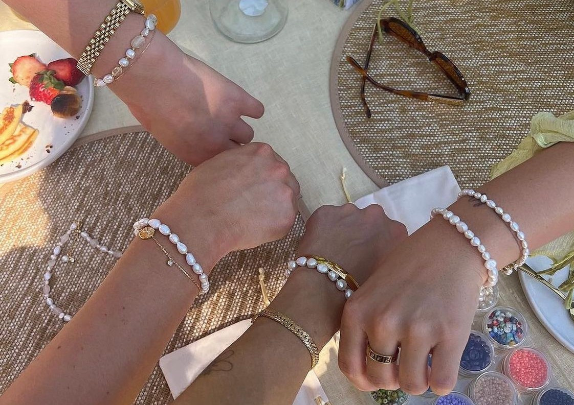 Three friends show off their handmade pearl jewellery