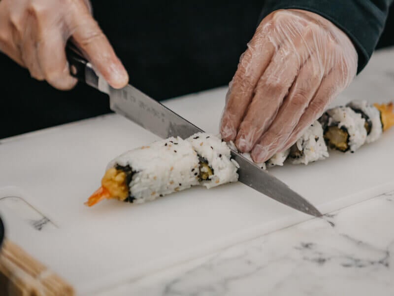 Handmade sushi getting sliced