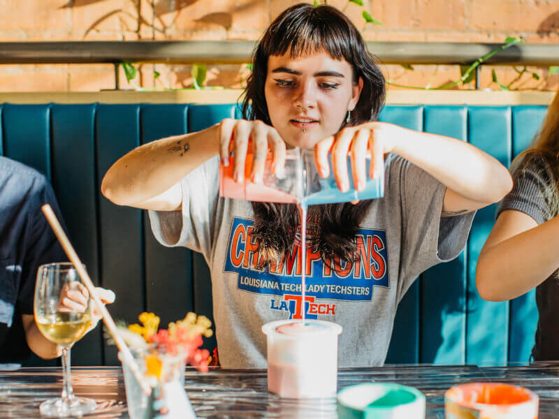 A woman making abstract art with paint pouring
