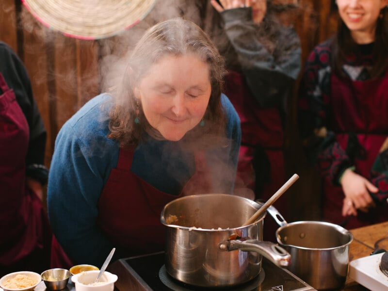 A woman at a cooking class delights in the smell of the food