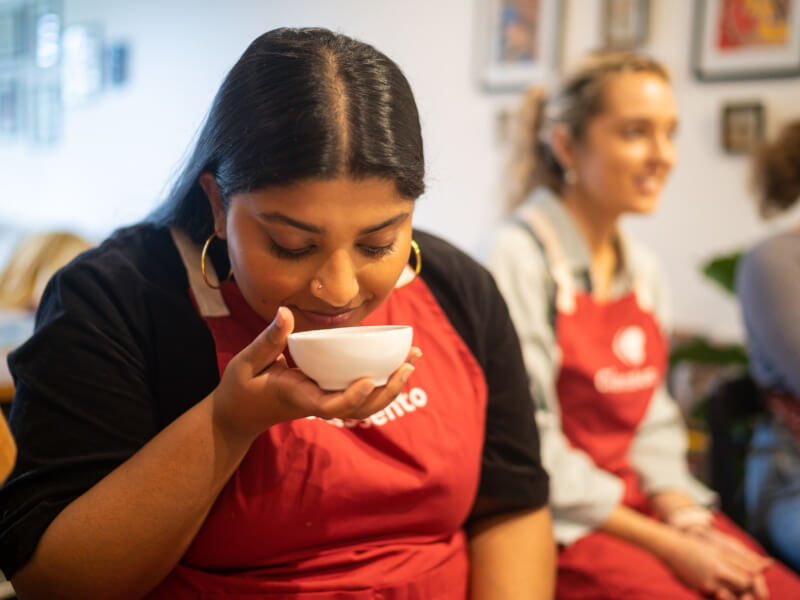 A woman smells spices at an Indian cooking class