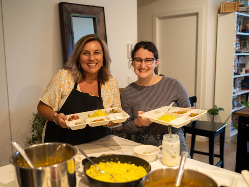 Two woman eat vegan Indian food at a cooking class in Brisbane