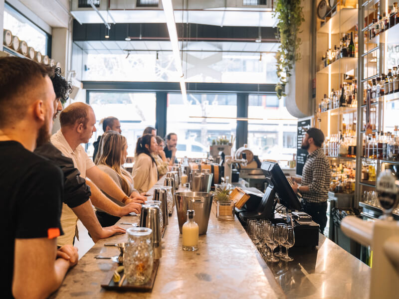 A team watches a cocktail demo at a cocktail class for corporate groups