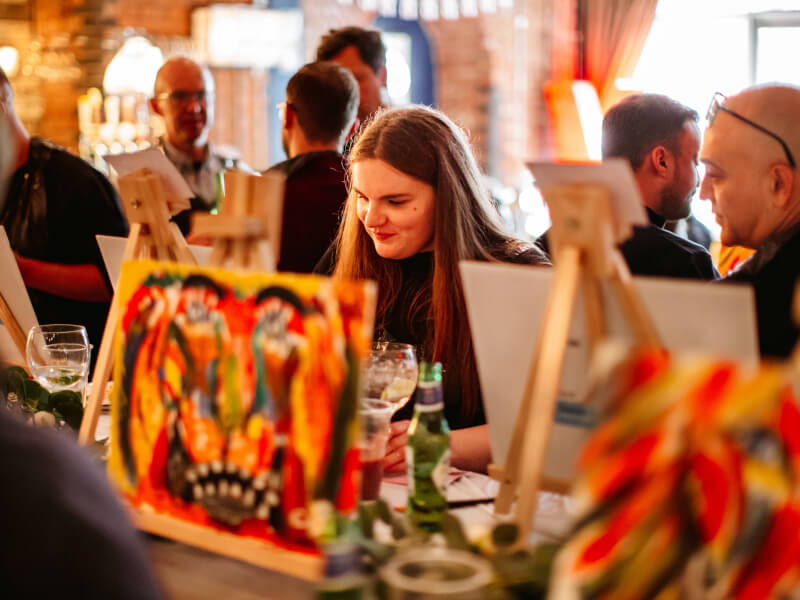Large group painting session at a paint and sip class for team building