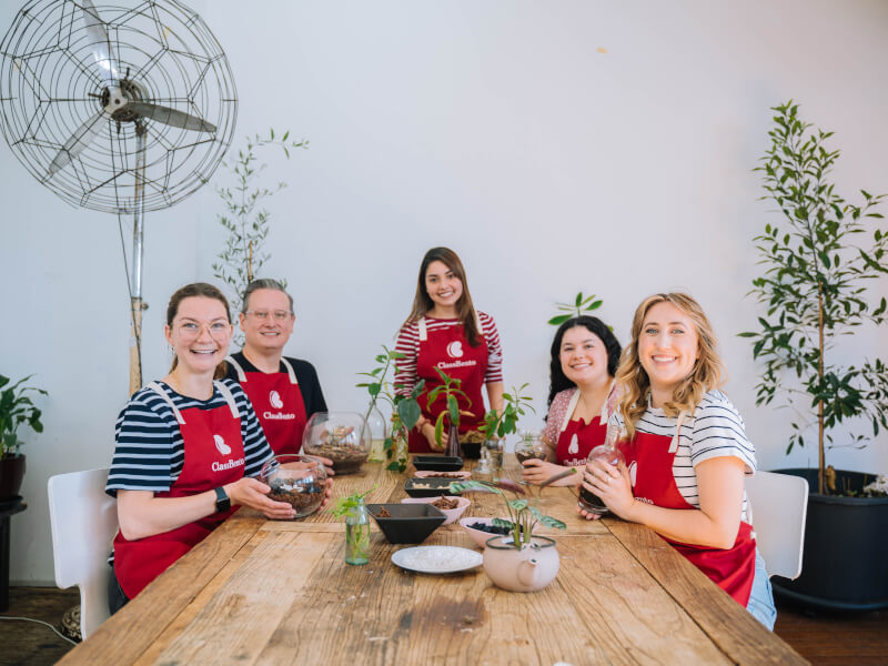 A group of colleagues show off their finished terrariums