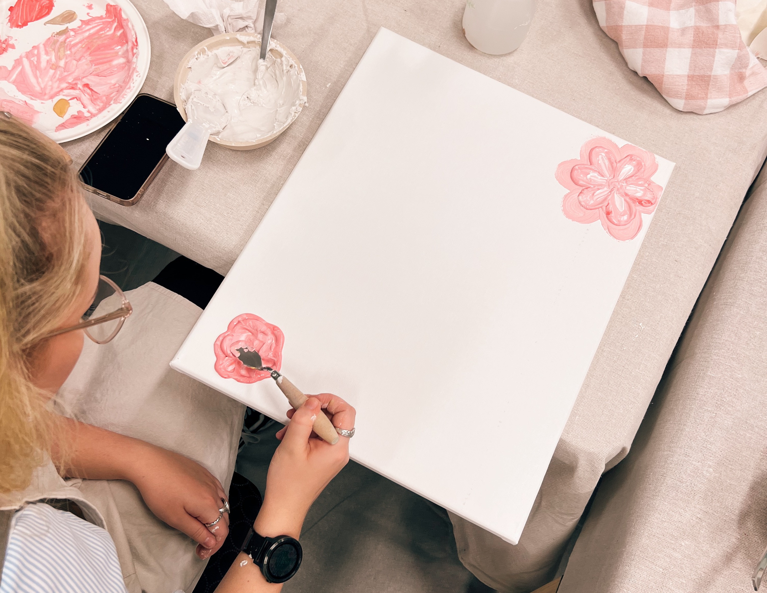 Woman painting textured art on canvas