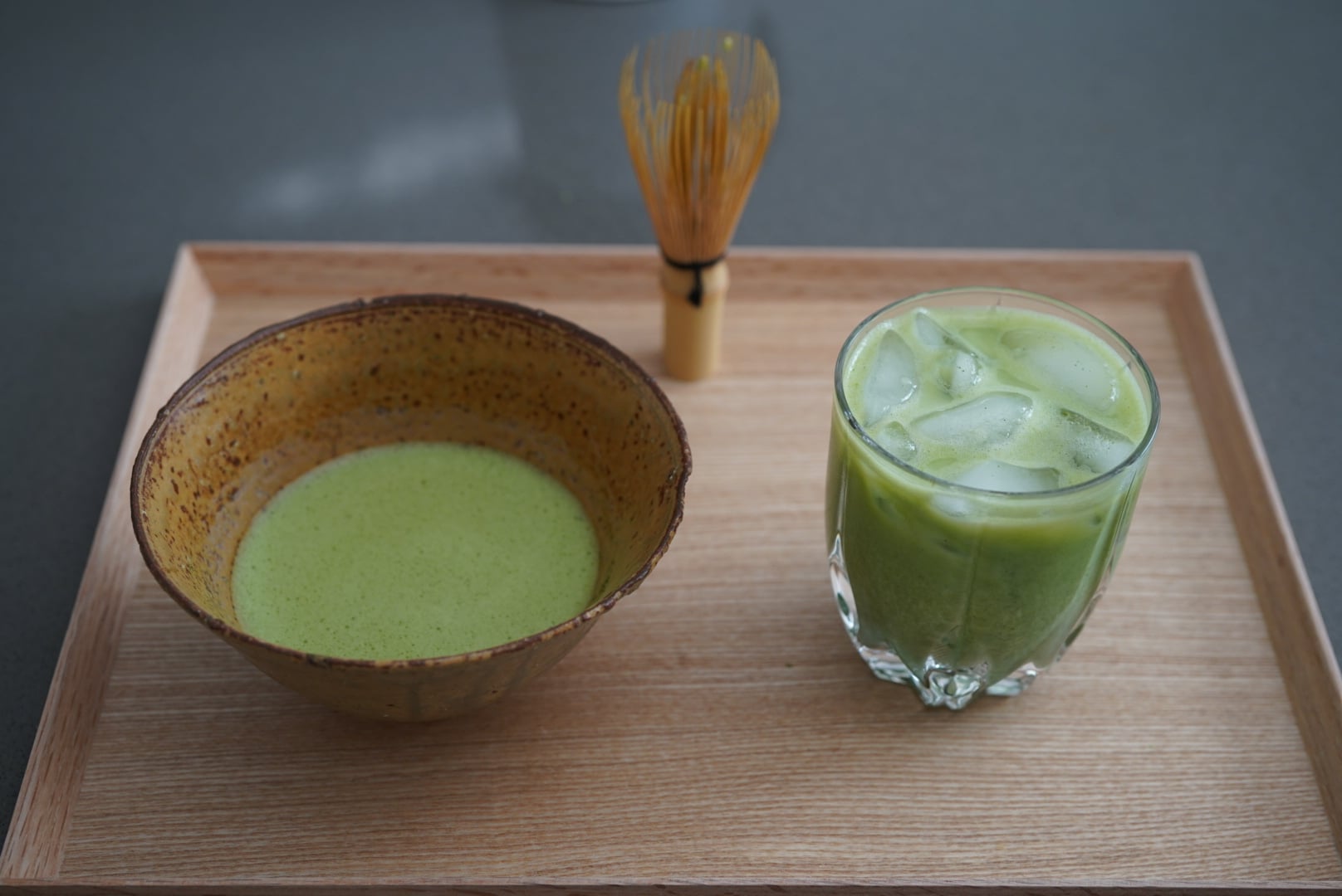 Iced matcha and matcha in a bowl laid out on a tray