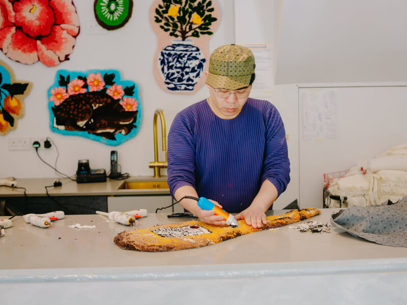 A man makes a rug at the tufting class he was gifted