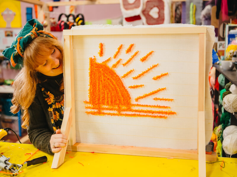 Woman proudly displaying her tufted creation