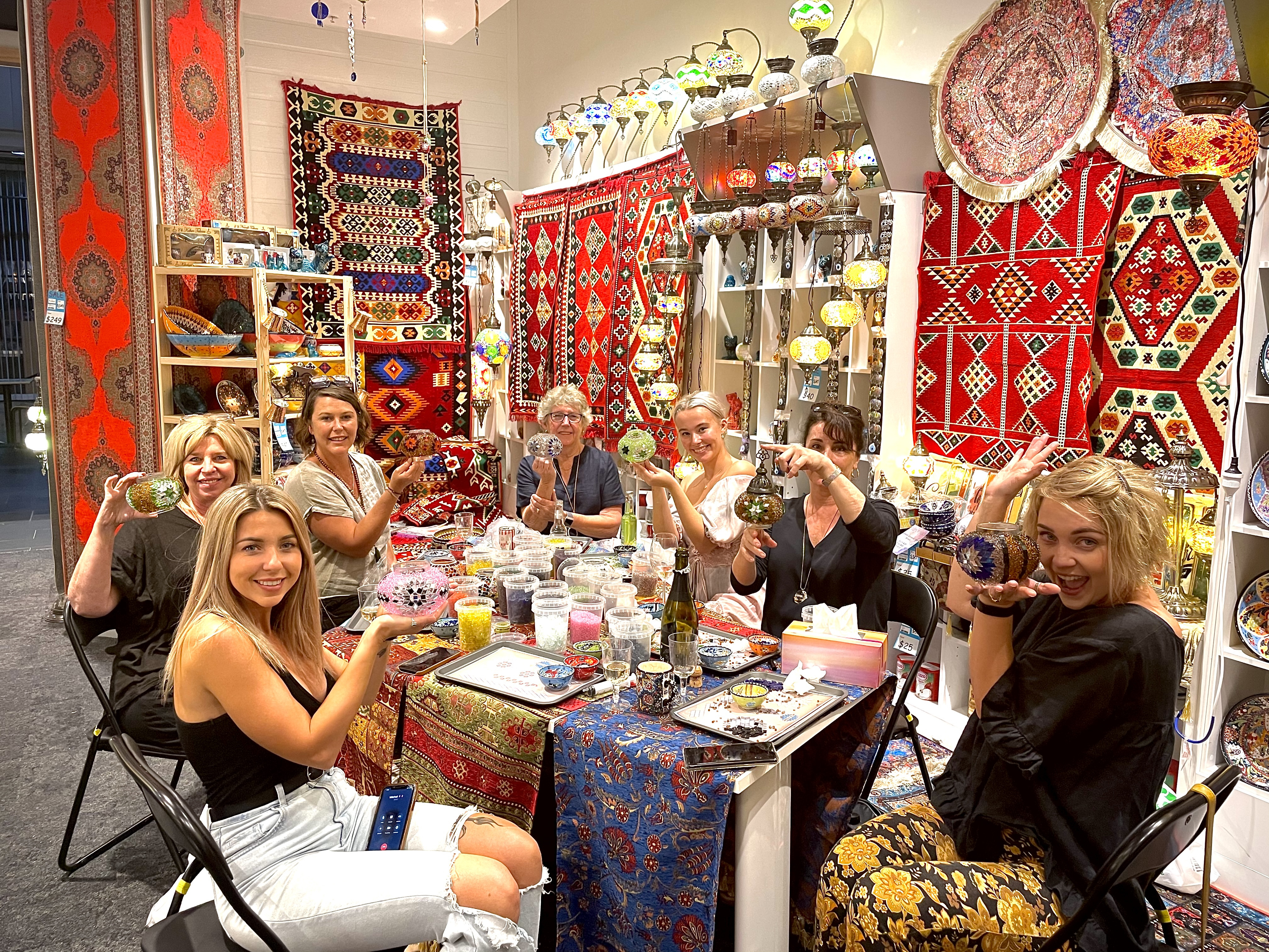 People holding up mosaic lamps