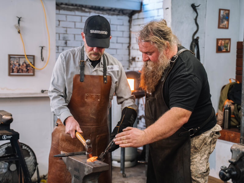 Two men makes knives at workshop they were gifted
