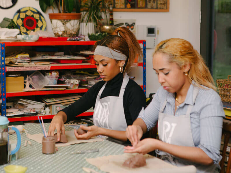 Two friends celebrate at a pottery workshop