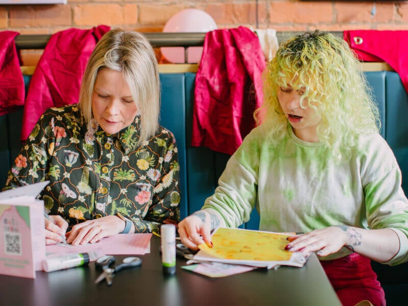 Two trendy friends at a collage workshop