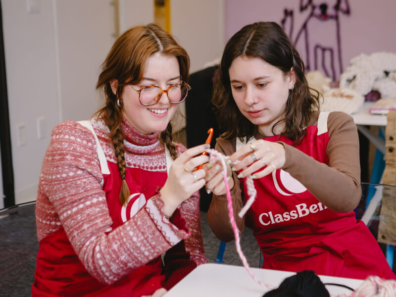 Two friends catch up at a knitting class