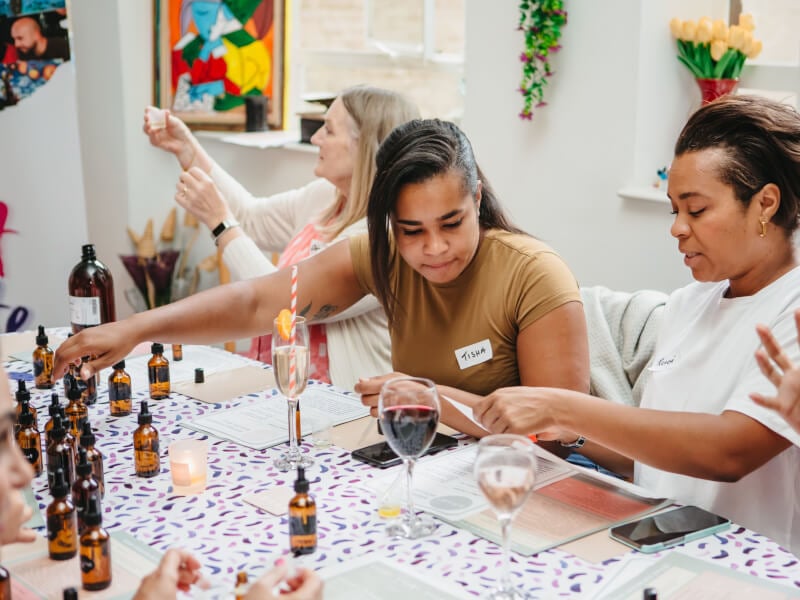 Two friends drink wine and make perfume at a workshop