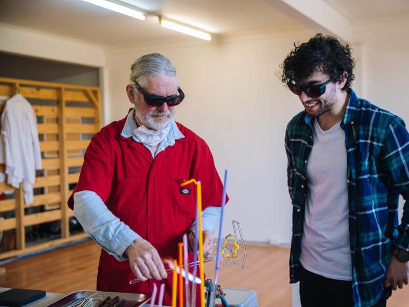Two men bonding at a glassblowing experience