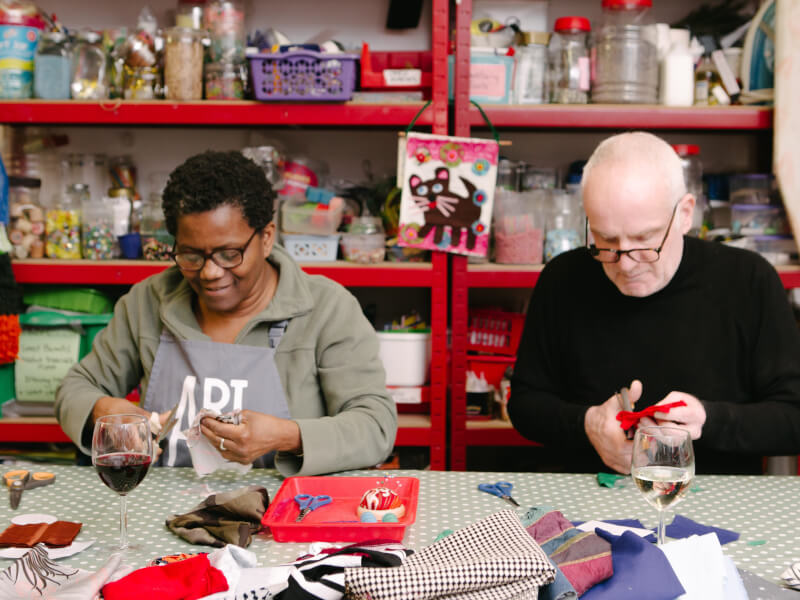 Two people sewing side by side at a sewing class
