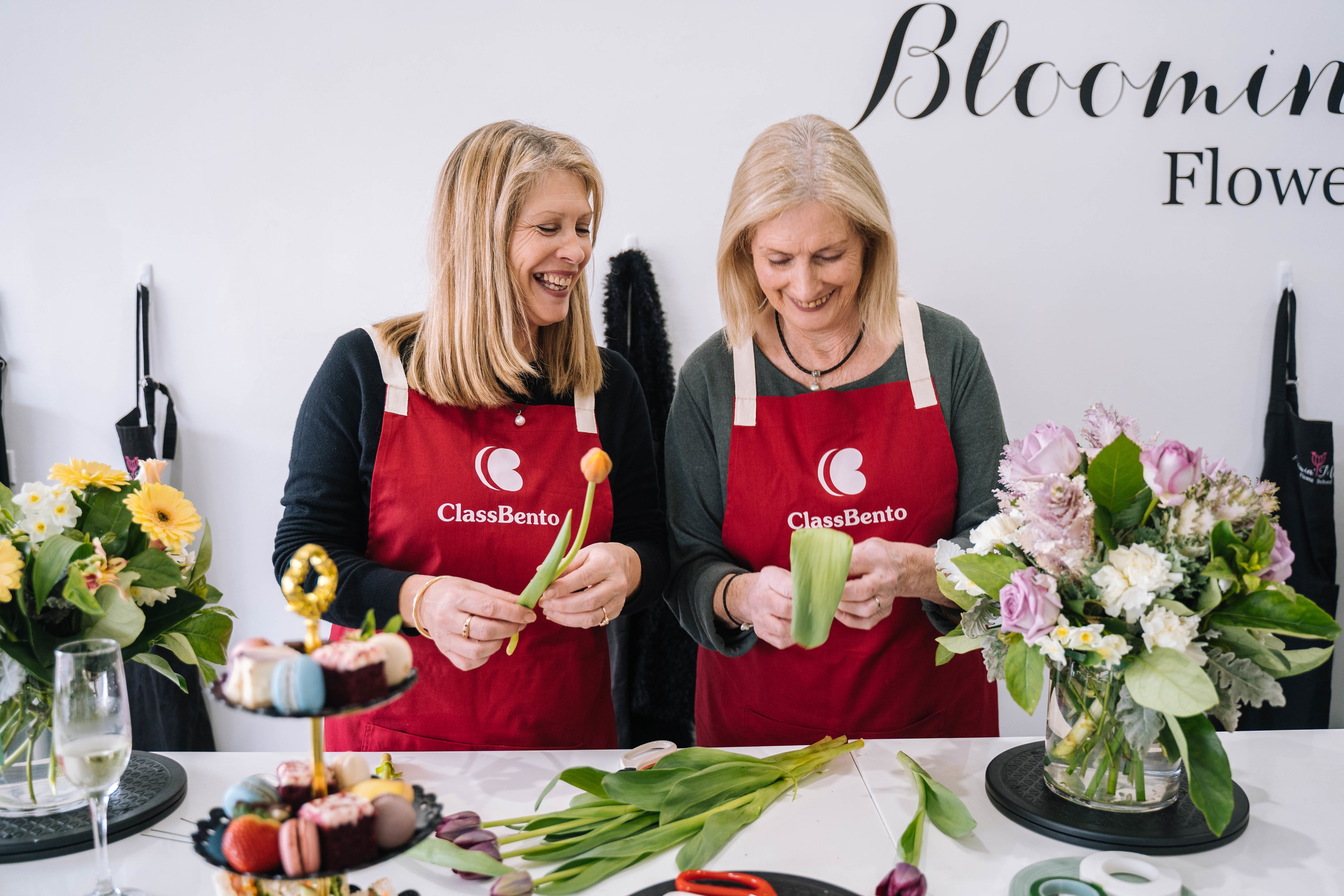 Two mothers arrange flowers at a floral experience they were gifted