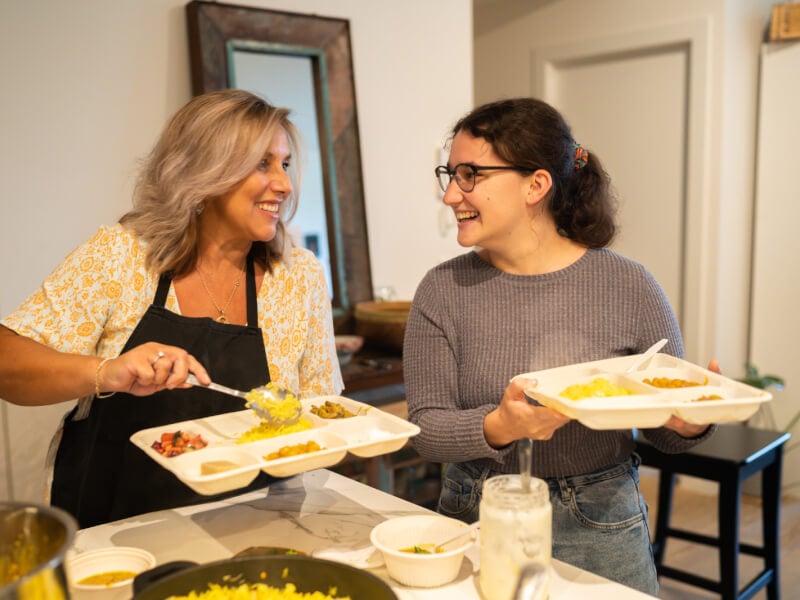 Two women enjoying homemade food they made at a mothers day cooking class