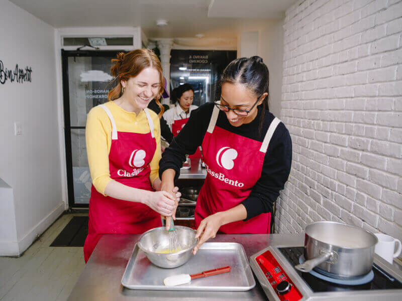 A couple share a mixing bowl at a cooking class