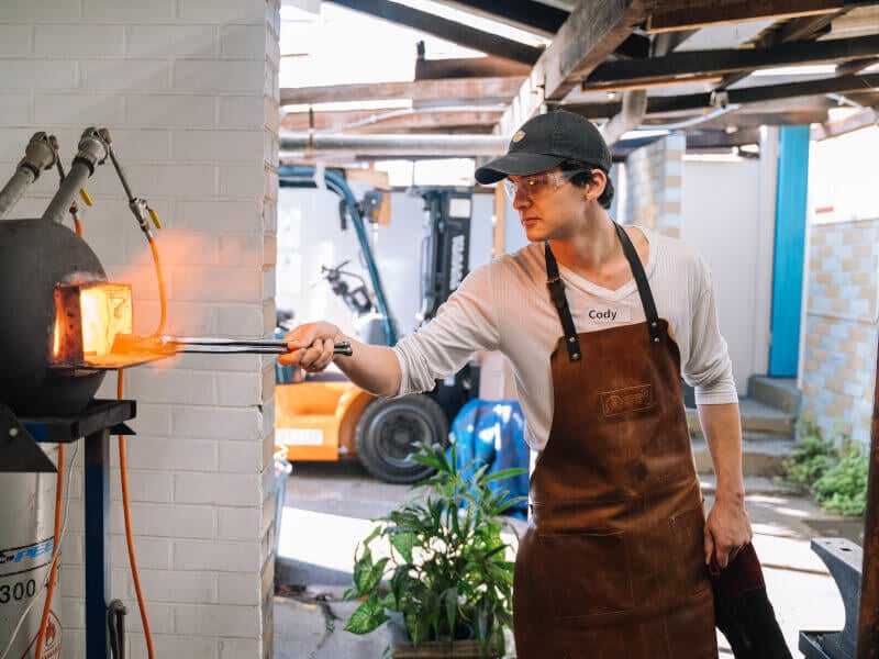 A man uses the forge at blacksmithing class he was gifted