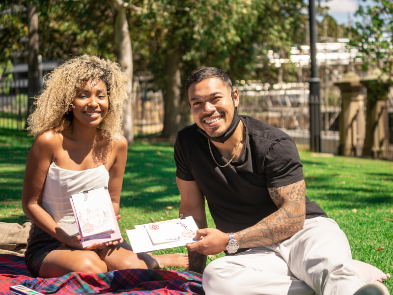 Two people smiling at an outdoor watercolour class for couples