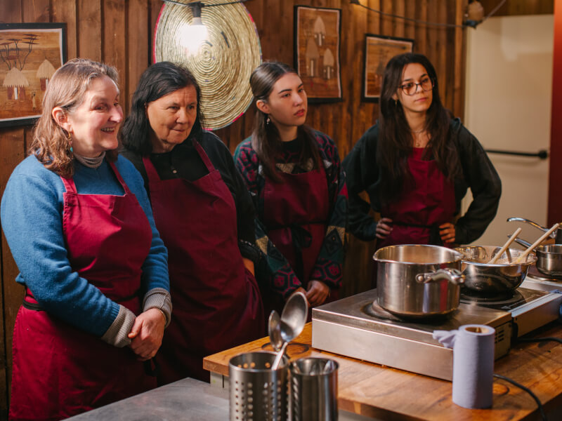 A group of cooking students watch a chef demonstration at an Adelaide cooking lesson