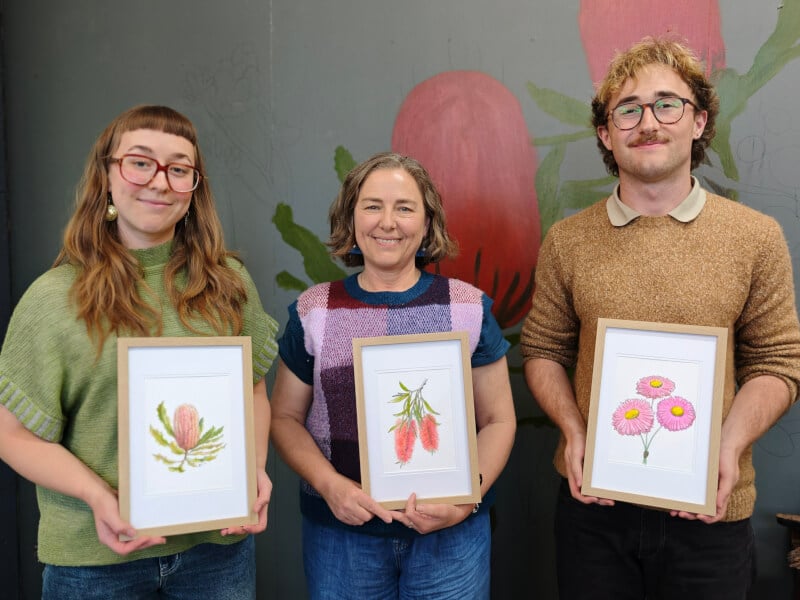 three people holding up their watercolour paintings