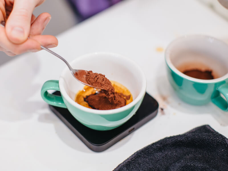 Weighing coffee into a cup at a coffee making class