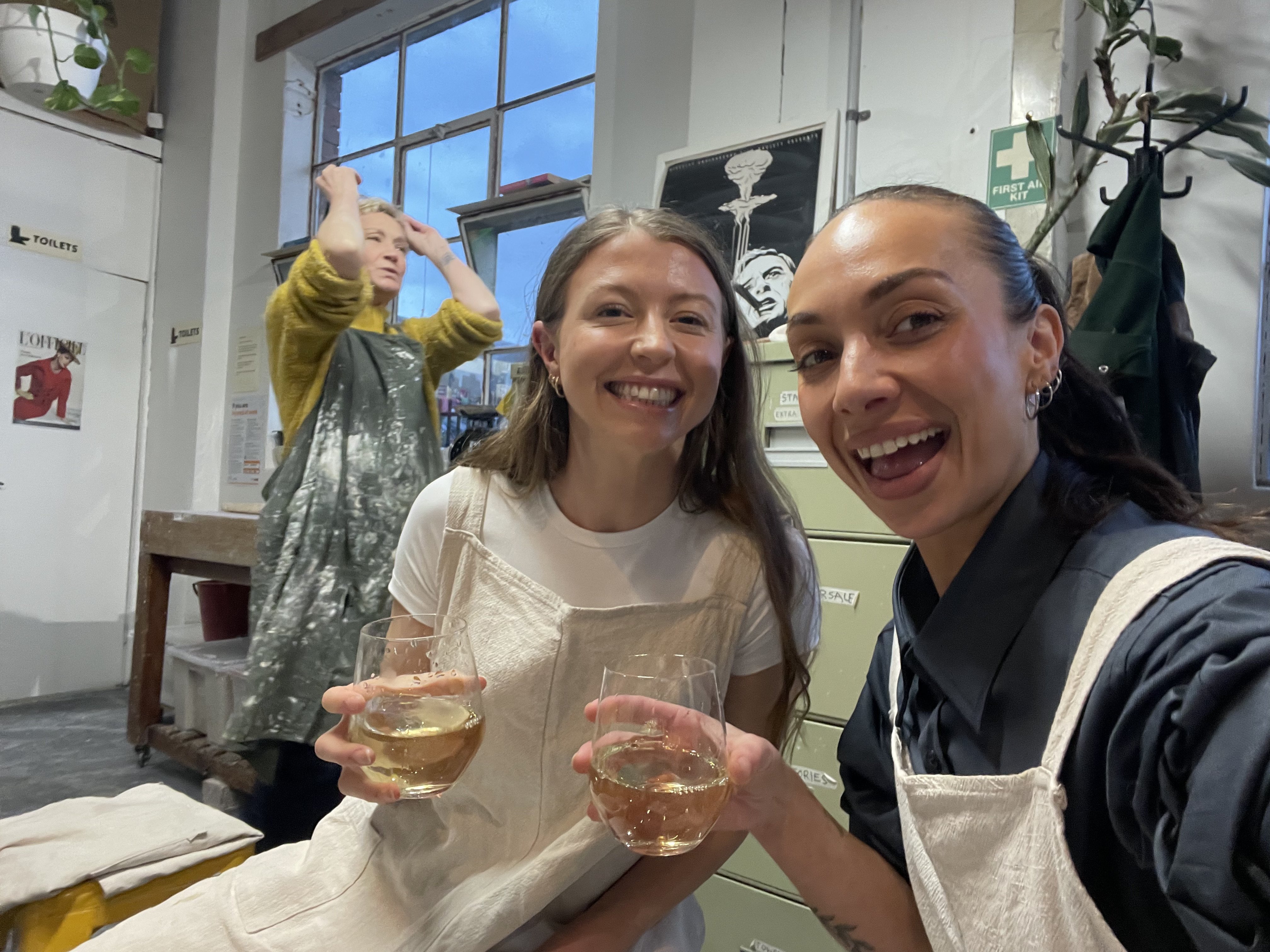 two girls taking a wheel throwing workshop