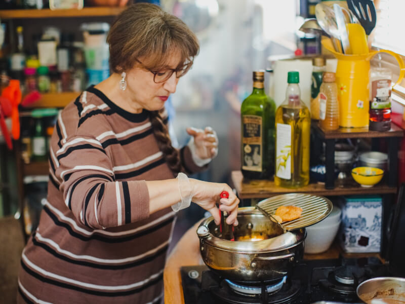 Woman cooking over pot at cooking class