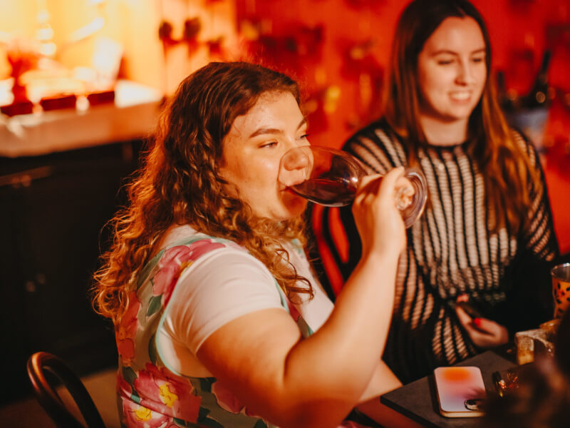 A 30-year old woman drinks wine with her friend